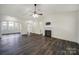 Open-concept living room with hardwood floors, a ceiling fan, fireplace, and arched doorways leading to other rooms at 6021 Piscataway Ct, Rock Hill, SC 29732