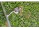 Aerial view of a house on a wooded lot with a long driveway, offering privacy and seclusion at 6171 Willow Farm Dr, Denver, NC 28037