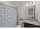 A cozy bathroom with a patterned shower curtain and a granite-topped vanity at 6171 Willow Farm Dr, Denver, NC 28037