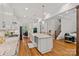 Open kitchen showcasing a large island, white cabinets, granite countertops, hardwood floors, and stainless steel appliances at 6171 Willow Farm Dr, Denver, NC 28037