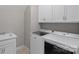 Laundry room features sink, updated washer and dryer, and upper cabinets for storage at 6171 Willow Farm Dr, Denver, NC 28037