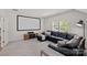 Bright living room features a large media screen, leather sofa, and plush carpeting at 6171 Willow Farm Dr, Denver, NC 28037