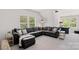 Living room features large black leather sofa, plush carpeting, and windows with views of the surrounding landscape at 6171 Willow Farm Dr, Denver, NC 28037