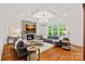 Inviting living room features a stone fireplace, hardwood floors, coffered ceilings, and comfortable seating at 6171 Willow Farm Dr, Denver, NC 28037
