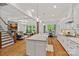 Spacious living area featuring hardwood floors, coffered ceilings, fireplace, and a view of the kitchen and breakfast nook at 6171 Willow Farm Dr, Denver, NC 28037