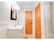 Modern bathroom featuring tiled flooring, wainscotting, a white vanity, and a wooden door at 619 E Sanders Rd, Shelby, NC 28150