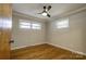 Bright bedroom features hardwood floors, neutral walls, windows, ceiling fan, and white trim at 619 E Sanders Rd, Shelby, NC 28150