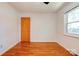 Bright bedroom with hardwood floors, white walls, a single window, and a wooden door at 619 E Sanders Rd, Shelby, NC 28150