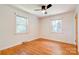 Bright bedroom with hardwood flooring, white walls, two windows, and a ceiling fan at 619 E Sanders Rd, Shelby, NC 28150
