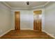 Bedroom with hardwood flooring, gray walls, white trim, two wooden doors and a ceiling fan at 619 E Sanders Rd, Shelby, NC 28150
