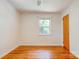 Bright bedroom with hardwood floors, white walls, a single window, and a wooden door at 619 E Sanders Rd, Shelby, NC 28150