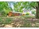 View of the side of the home showing the large yard and mature trees at 619 E Sanders Rd, Shelby, NC 28150