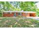 Charming brick ranch home featuring a carport, mature trees and nicely landscaped front yard at 619 E Sanders Rd, Shelby, NC 28150