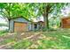 Exterior view of a shed with gray siding and a wood door, set against a backdrop of trees and lawn at 619 E Sanders Rd, Shelby, NC 28150
