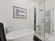 Bright bathroom featuring a modern tub, glass enclosed shower, and neutral decor at 6309 Wakehurst Rd, Charlotte, NC 28226