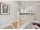 Upstairs hallway with white banister and hardwood floors at 6309 Wakehurst Rd, Charlotte, NC 28226