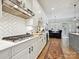 Stylish white kitchen with herringbone backsplash, modern appliances, and a view into the dining area at 6309 Wakehurst Rd, Charlotte, NC 28226