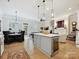 Open-concept kitchen featuring a large island with wine cooler and elegant pendant lighting at 6309 Wakehurst Rd, Charlotte, NC 28226