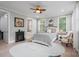 Comfortable bedroom with a decorative ceiling fan, a patterned bedspread, and a faux fireplace at 685 Knollcrest Ne Dr, Concord, NC 28025