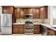 Spacious kitchen featuring stainless steel appliances, ample counter space, and dark wood cabinets at 7324 Jolly Brook Dr, Charlotte, NC 28215