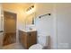 Bathroom boasts a modern vanity with marble countertop, fixtures, and wood cabinetry at 7426 Hambright Rd, Huntersville, NC 28078