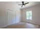 Bedroom features neutral carpeting, a ceiling fan, and a closet for storage at 7426 Hambright Rd, Huntersville, NC 28078