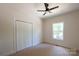 Bedroom features neutral carpeting, a ceiling fan, and a closet for storage at 7426 Hambright Rd, Huntersville, NC 28078