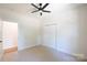 Bright bedroom features plush carpet, ceiling fan, and a large closet with bi-fold doors at 7426 Hambright Rd, Huntersville, NC 28078