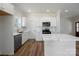 Modern kitchen with quartz countertops, white cabinets, stainless appliances, and stylish fixtures at 7426 Hambright Rd, Huntersville, NC 28078