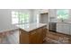 Spacious kitchen features a wooden island with white granite countertop and luxury finishes at 7426 Hambright Rd, Huntersville, NC 28078