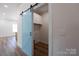 A charming laundry room with a sky-blue sliding barn door and overhead storage cabinets at 7426 Hambright Rd, Huntersville, NC 28078