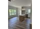Open living space with an island bar with view into the kitchen, hardwood floors and ample natural light at 7426 Hambright Rd, Huntersville, NC 28078