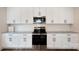 Well-lit kitchen featuring stainless steel appliances and modern white cabinetry with dark hardware at 746 Shasta Nw St, Concord, NC 28027