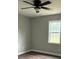 This bedroom features dark wood floors, ceiling fan, and a window overlooking the yard at 8222 Madison Ln, Hickory, NC 28602