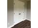 A closet featuring white doors with matte black hardware and dark wood floors at 8222 Madison Ln, Hickory, NC 28602