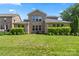 Well-maintained backyard featuring a manicured lawn, mature landscaping, and a patio seating area at 8514 Ellington Park Dr, Charlotte, NC 28277
