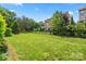 Expansive fenced backyard with lush green grass and mature trees, perfect for outdoor activities at 8514 Ellington Park Dr, Charlotte, NC 28277