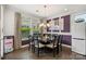 Formal dining room with a large square table, decorative curtains, and hardwood floors at 8514 Ellington Park Dr, Charlotte, NC 28277
