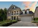 Elegant two-story brick home with a covered porch, dormer windows, and a spacious two-car garage at 8514 Ellington Park Dr, Charlotte, NC 28277