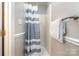 Bathroom features a white shower and light grey and white striped shower curtain at 8544 Houston Ridge Rd, Charlotte, NC 28277