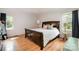 Bright bedroom with wood floors features a dark wood sleigh bed with white linens at 8544 Houston Ridge Rd, Charlotte, NC 28277