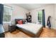 Bedroom with wood floors features a dark wood bed and two bright, sunny windows at 8544 Houston Ridge Rd, Charlotte, NC 28277