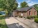 Charming brick home featuring well-maintained landscaping, a spacious driveway, and cozy outdoor seating area at 8544 Houston Ridge Rd, Charlotte, NC 28277