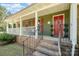 Charming home exterior showcasing a covered front porch, red door, and well-maintained landscaping at 8544 Houston Ridge Rd, Charlotte, NC 28277