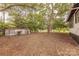 View of the backyard and storage shed from under a mature shade tree on the side of the property at 10 Bolt Dr, Shelby, NC 28150