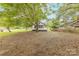 This spacious backyard features partial fencing and a mature shade tree, with street views and a neighbor's home at 10 Bolt Dr, Shelby, NC 28150