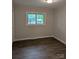 A bright bedroom featuring dark wood floors and a window offering a view of the outdoors at 1002 Hemlock Dr, Shelby, NC 28150