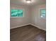 A bright bedroom featuring dark wood floors and two windows, bringing in natural light and views at 1002 Hemlock Dr, Shelby, NC 28150