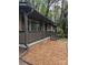 Charming brick home exterior featuring a covered front porch with tasteful gray accents and wood-chip landscaping at 1002 Hemlock Dr, Shelby, NC 28150