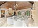Spacious living room with a grand chandelier, wood ceiling, fireplace, and lots of natural light at 1118 Seminole Dr, Fort Mill, SC 29707